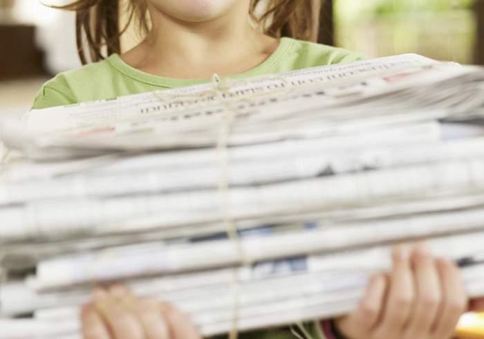 girl recycling newspapers